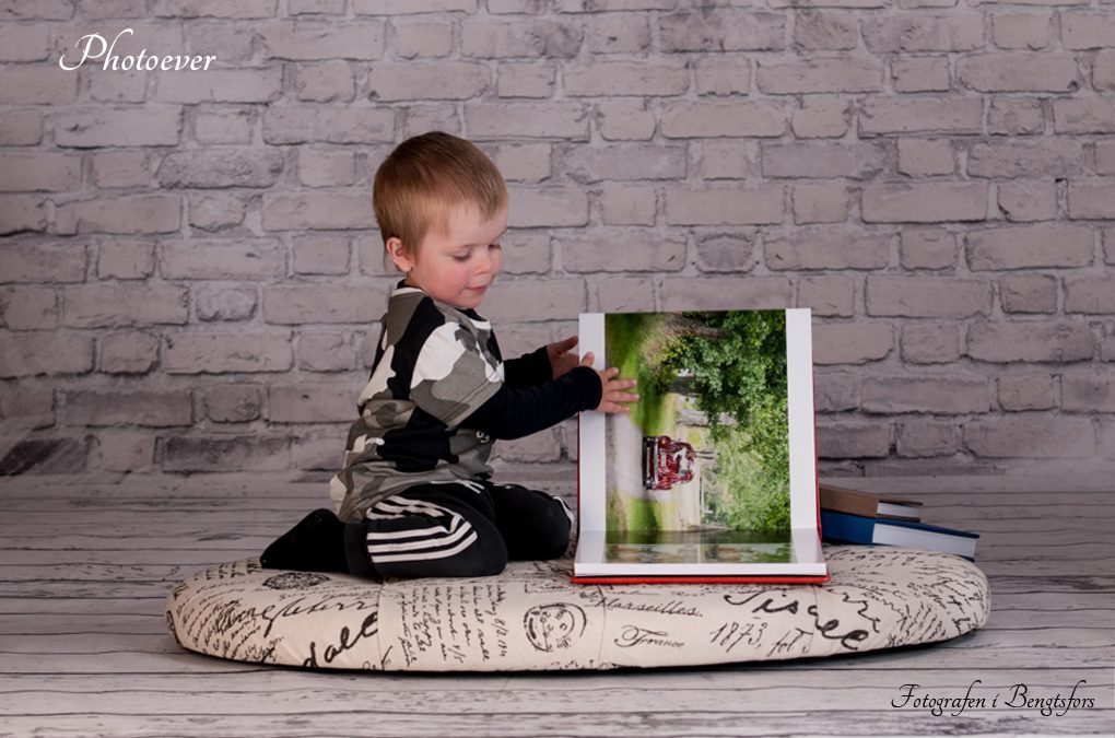 en pojke tittar i fotoböcker från Photoever